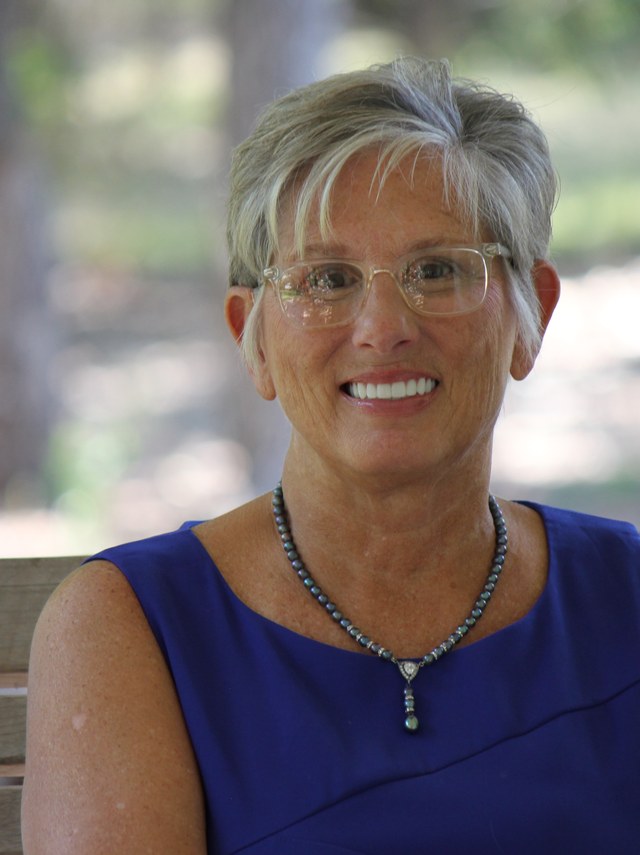Sharon King, founder of Mercy Manor, seated outdoors.